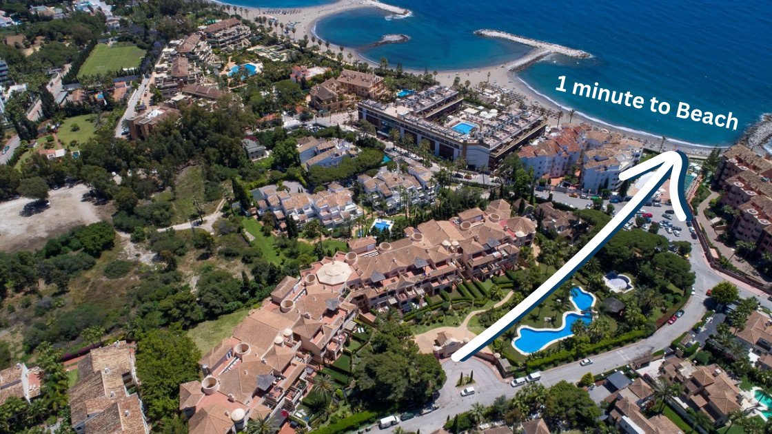 Aerial view of a resort complex with pools, lush greenery, and proximity to the beach.