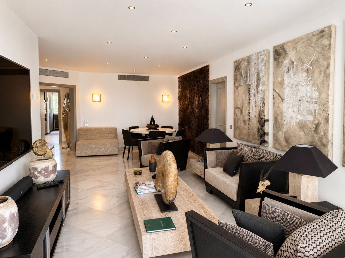 Modern living room featuring a large marble coffee table, beige sofas, and abstract wall art