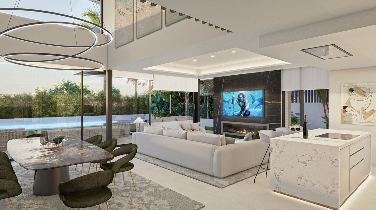 Modern open-plan living area with dining table, sofa, fireplace, TV, and kitchen island, overlooking a swimming pool.