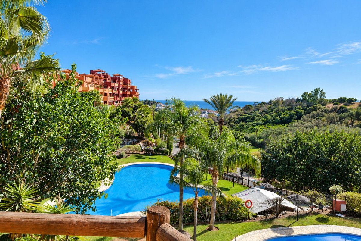 Apartment with pool, sea view, and palm trees in sunny landscape