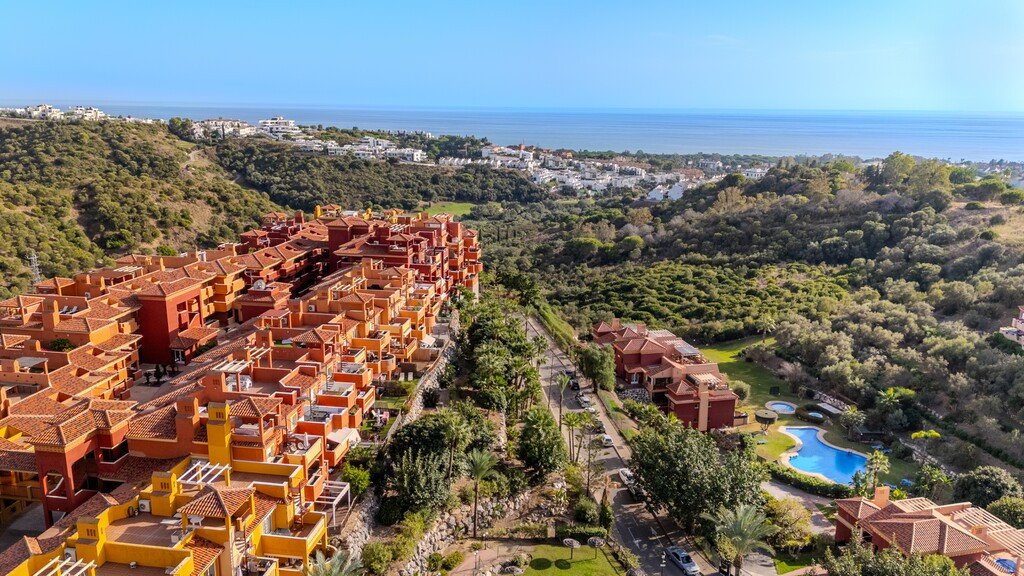 Aerial view of an apartment complex with sea and pool views