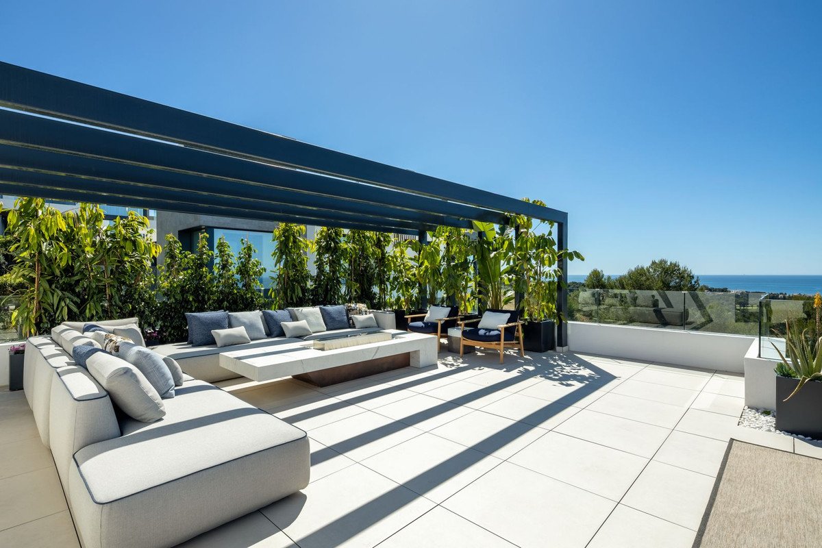 Modern rooftop terrace with outdoor lounge, sea view, and greenery