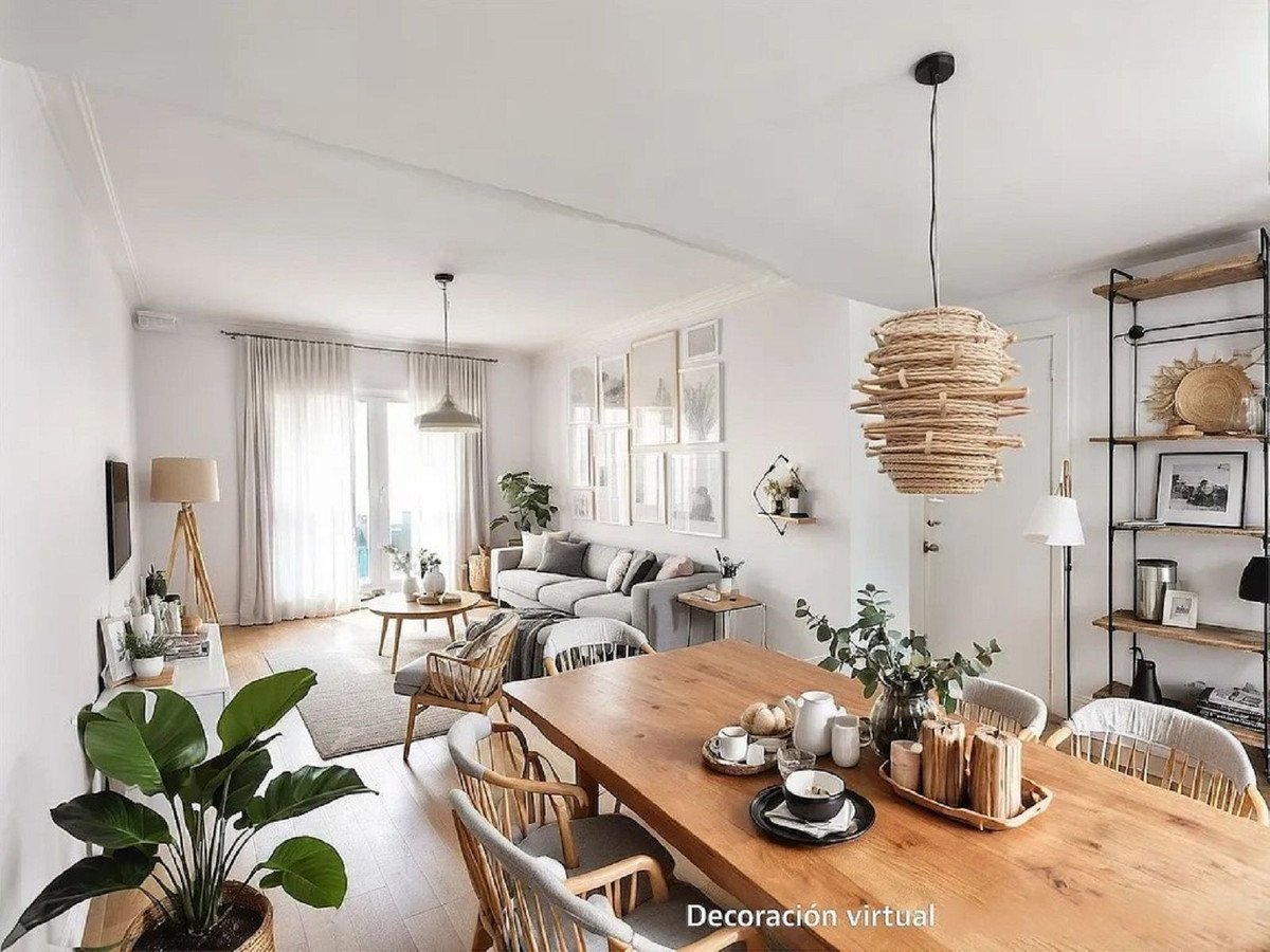 Open-plan living and dining room with wooden table, sofa, plants, and pendant lights