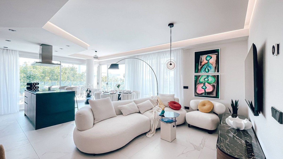 Modern living room with open plan layout, white curved sofa, and large windows