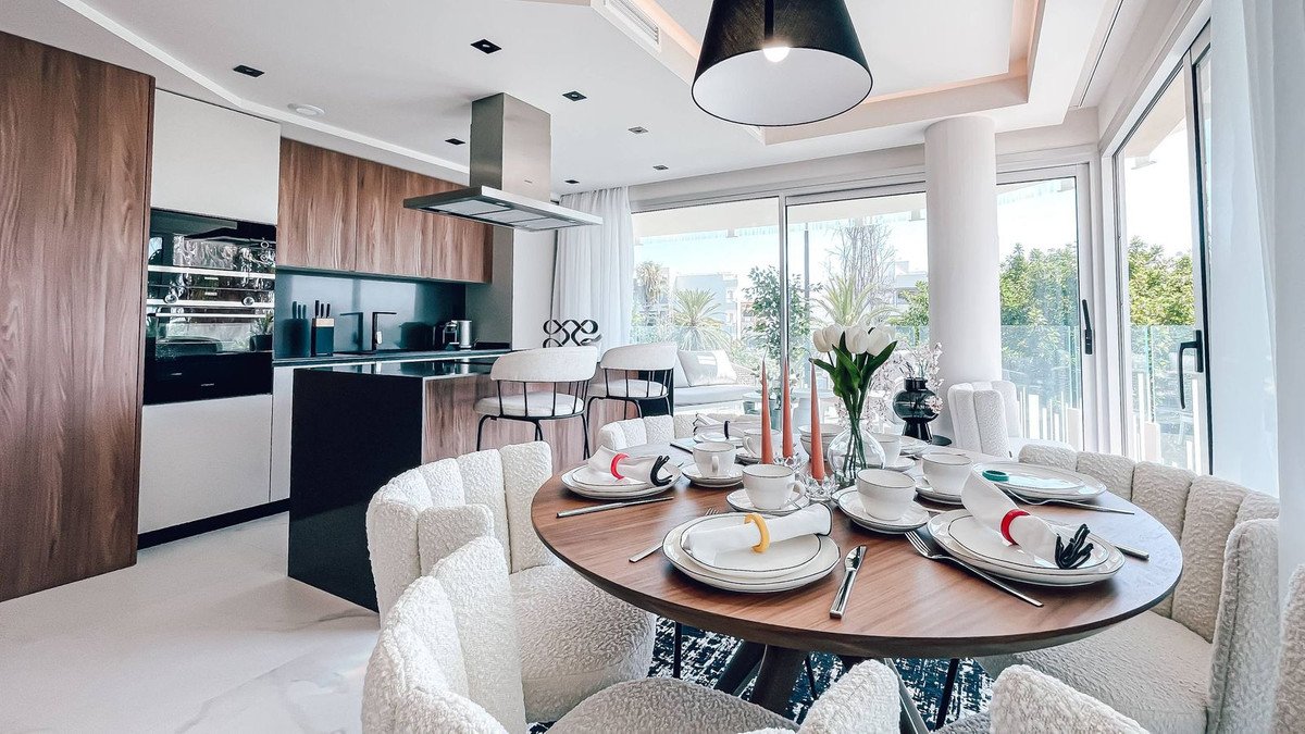 Modern open-plan dining and living area with kitchen and large windows