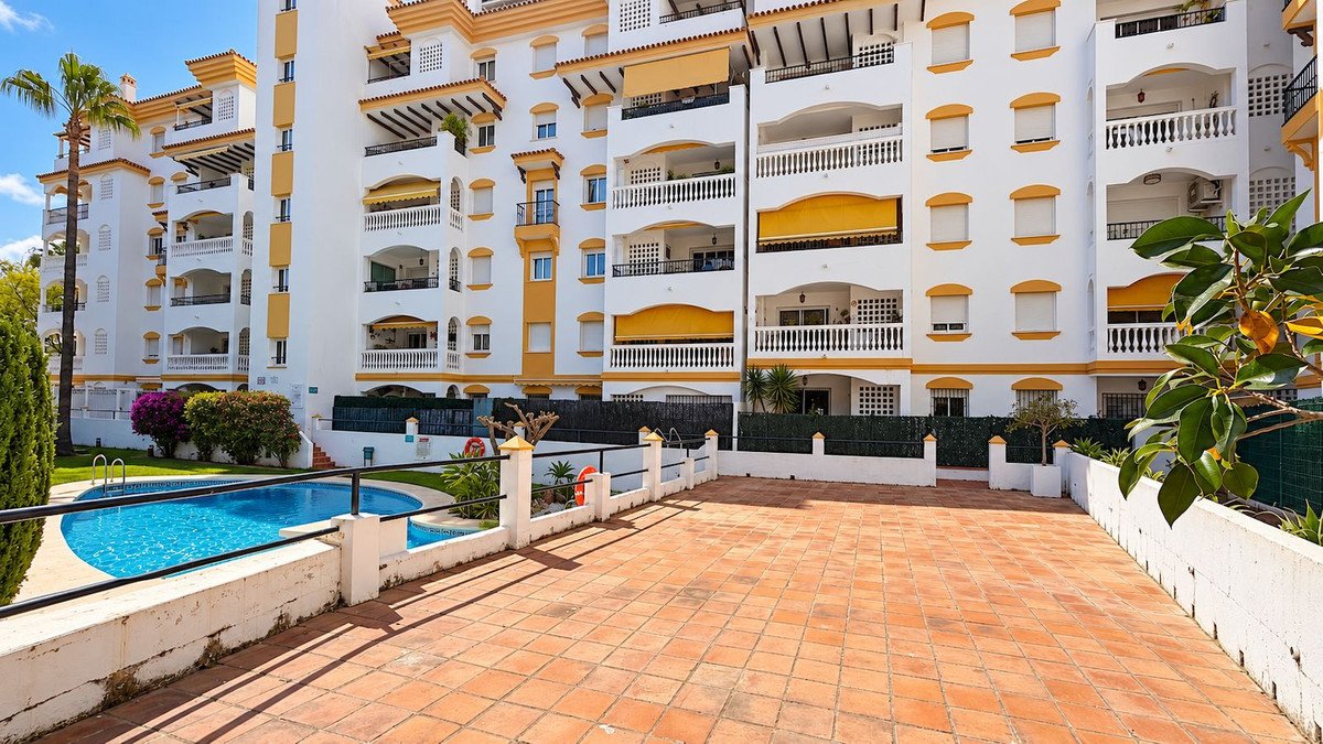 Apartment complex with swimming pool and tiled patio area