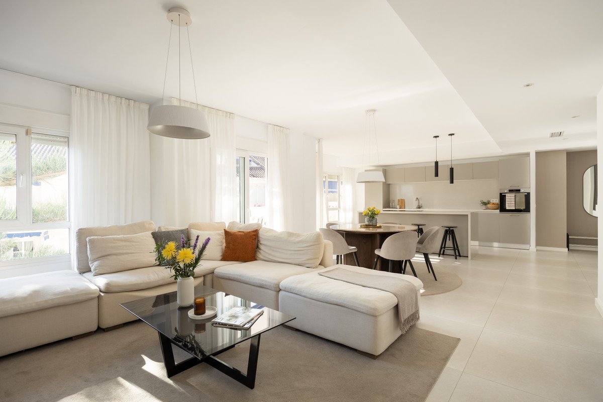 Modern living room with open plan kitchen, large sofa, glass coffee table