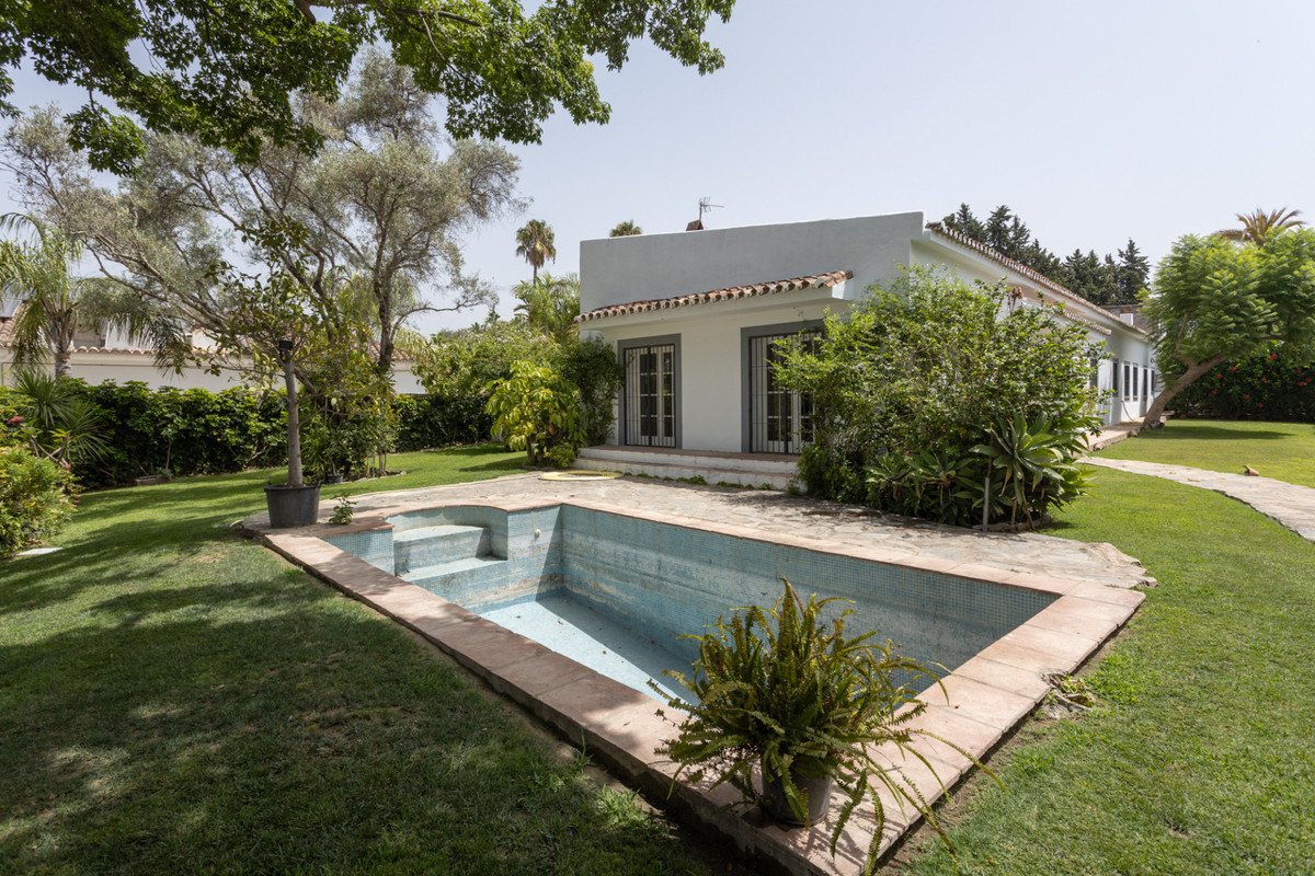 White villa with swimming pool and lush garden
