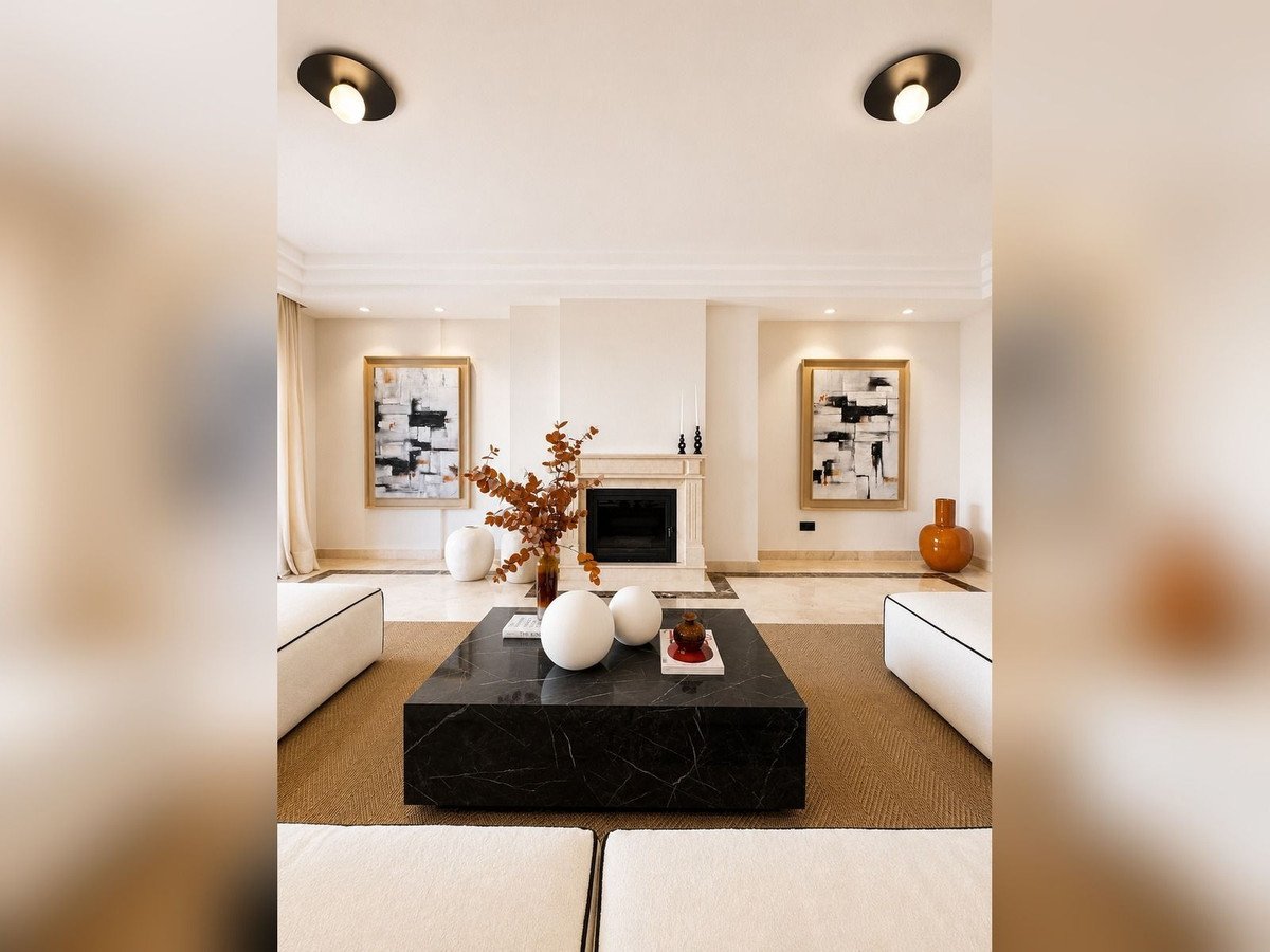 Modern living room with fireplace, abstract art, and black coffee table