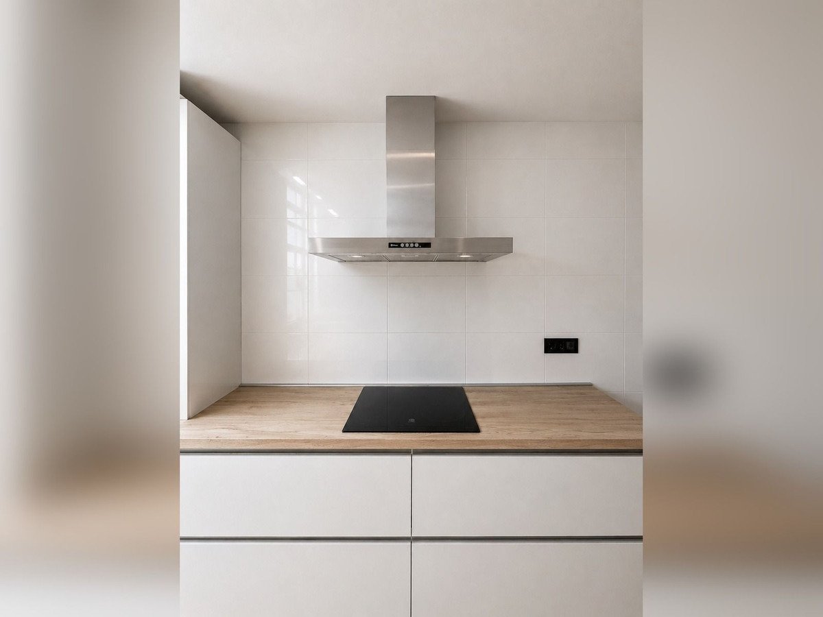 Modern kitchen with stainless steel range hood and light wood countertop
