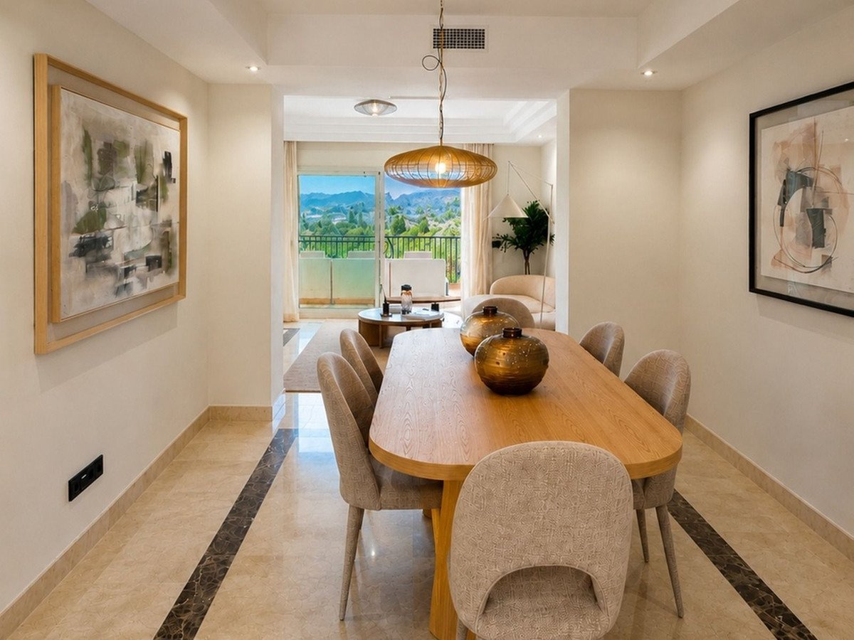 Modern dining room with wooden table, chairs, and mountain view through large windows