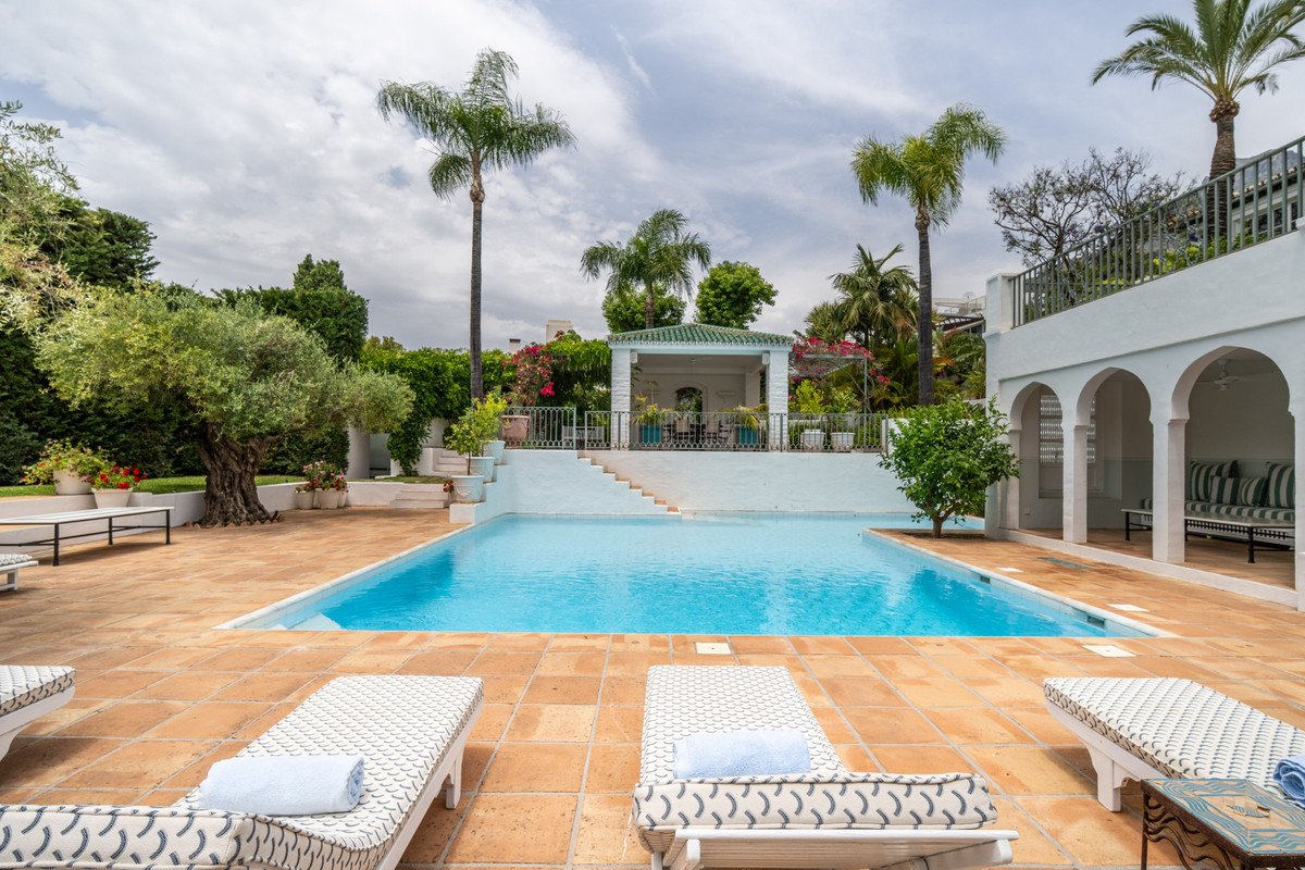 Luxurious swimming pool with lounge chairs and tropical garden view