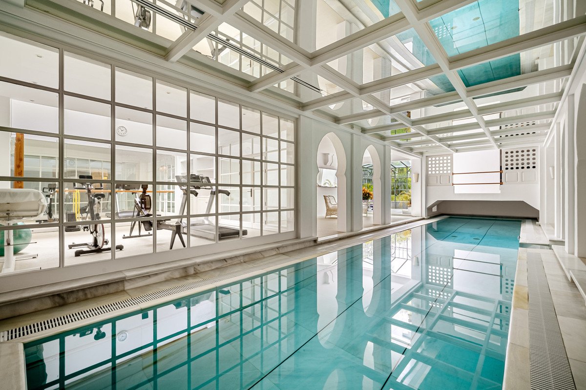 Indoor swimming pool with gym equipment and large windows