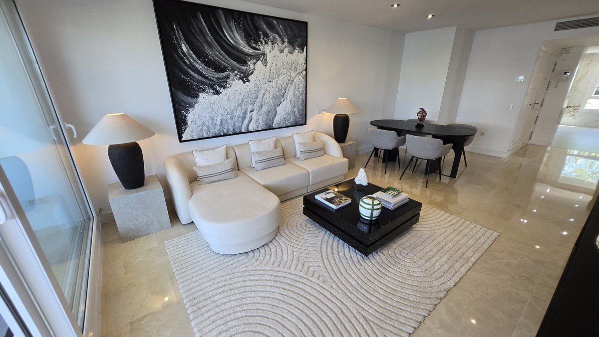 Modern living and dining area with a sectional sofa, coffee table, dining set, and abstract art above the sofa.