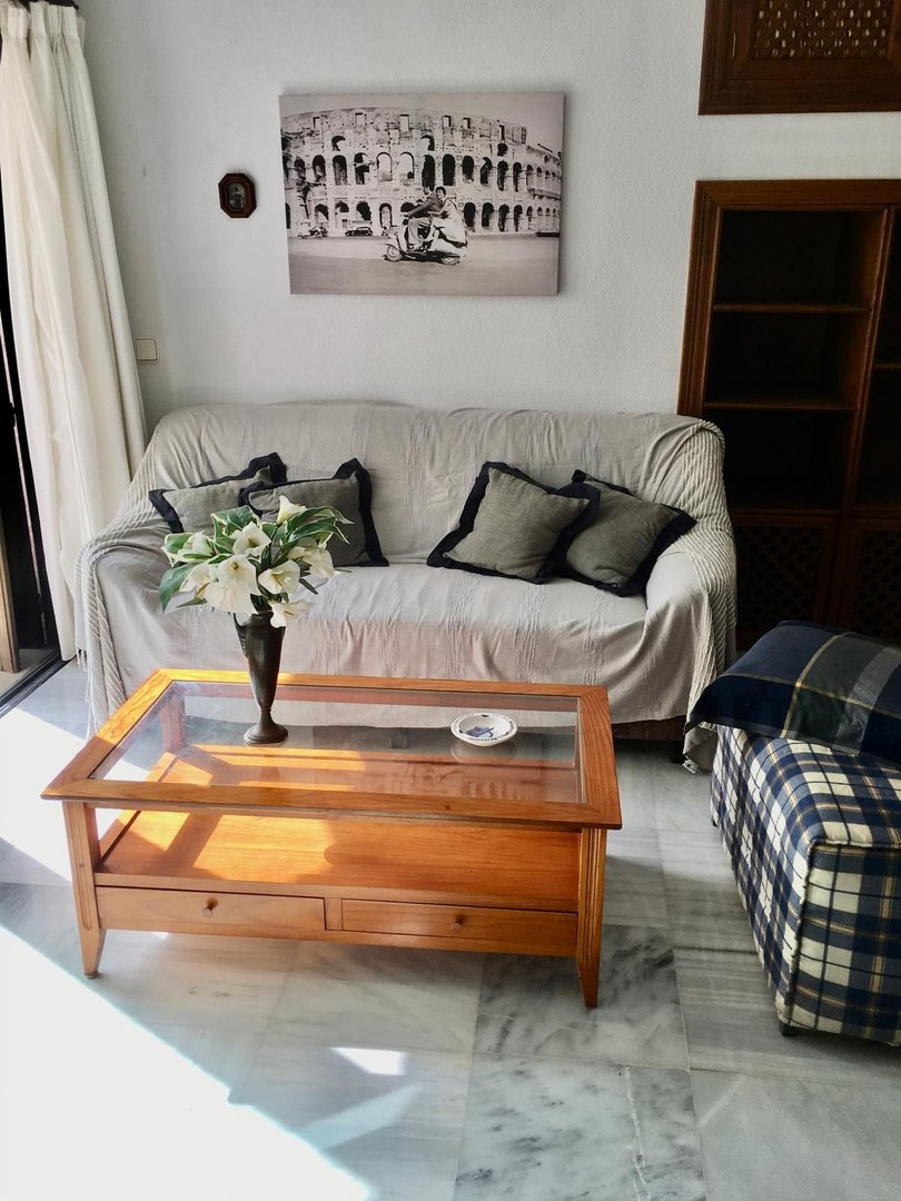 Living room with a sofa, coffee table, and artwork of the Colosseum. Offers a comfortable seating area.