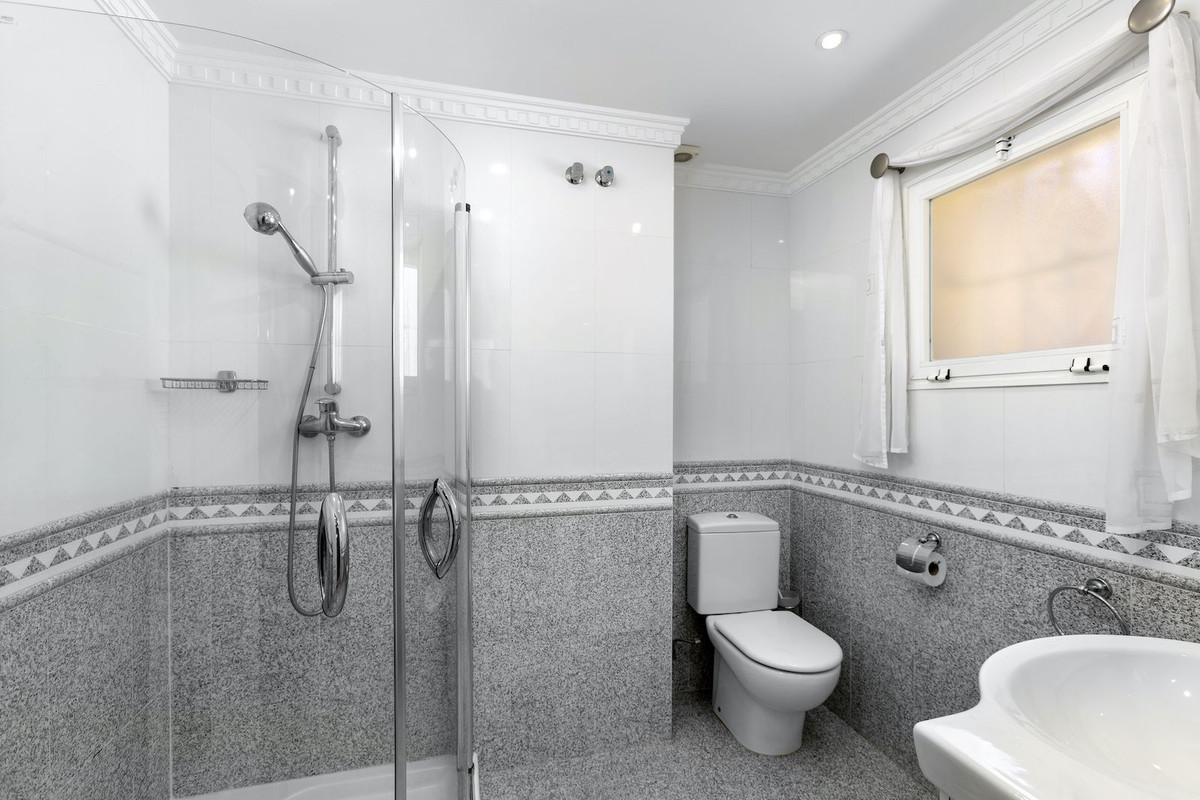 Moderne badkamer met douchecabine, toilet en wastafel.