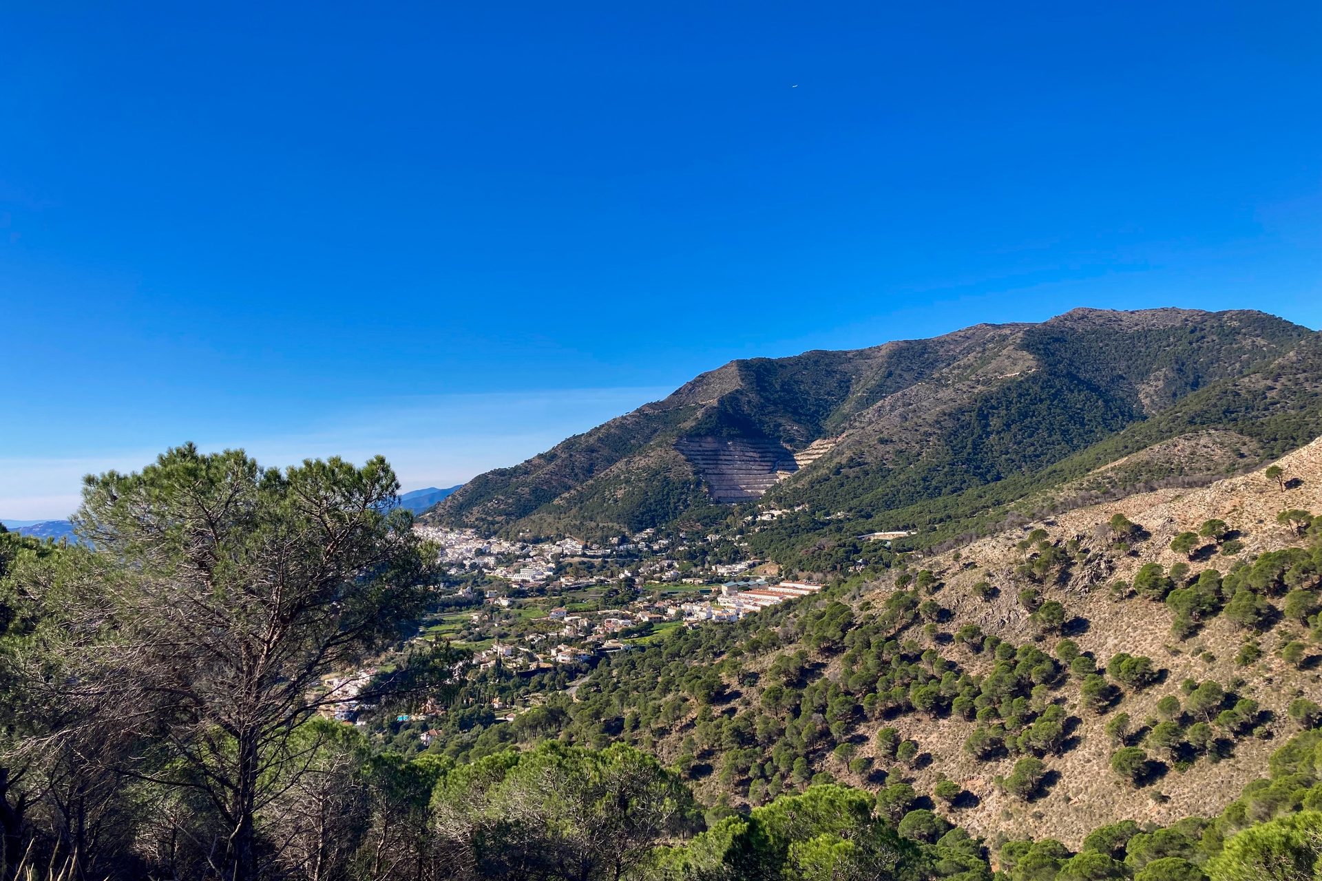 Alt text: Panoramic view of a mountainous landscape with a small town below.
