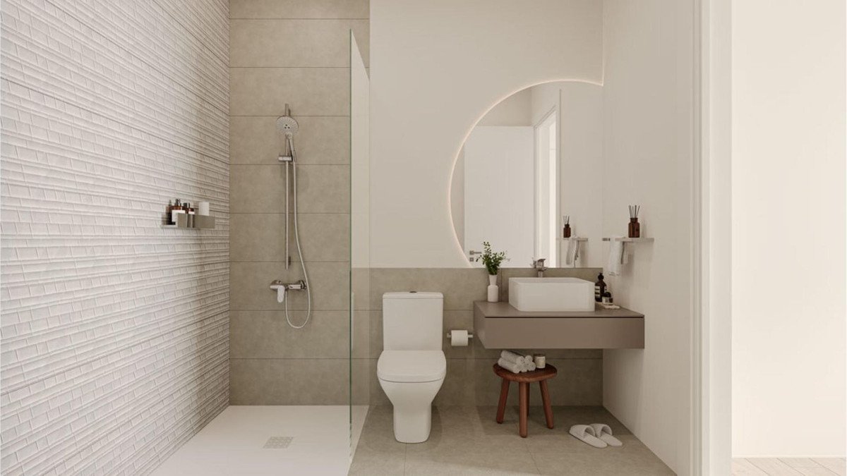 Modern bathroom with a walk-in shower, toilet, and a floating vanity with a rectangular sink and round mirror.