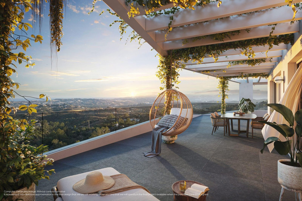 Luxe terras in Mijas met zeezicht en hangstoel.