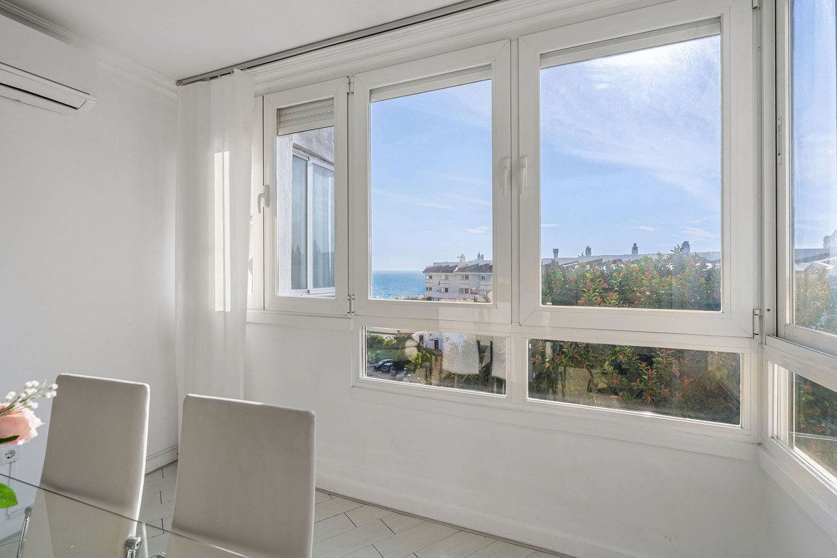 Bright dining room with large windows offering sea and city views