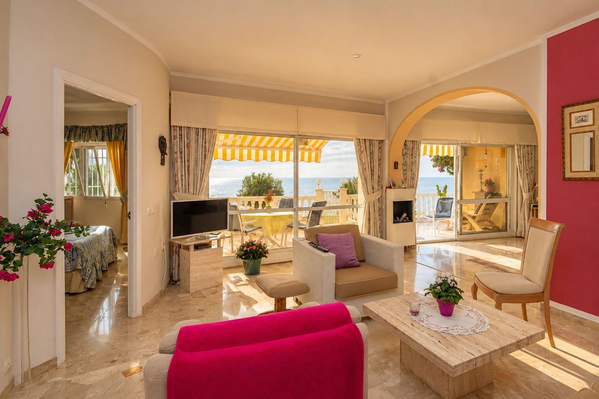 Living room with modern furniture, a fireplace, and a large window with a beautiful sea view and terrace access.