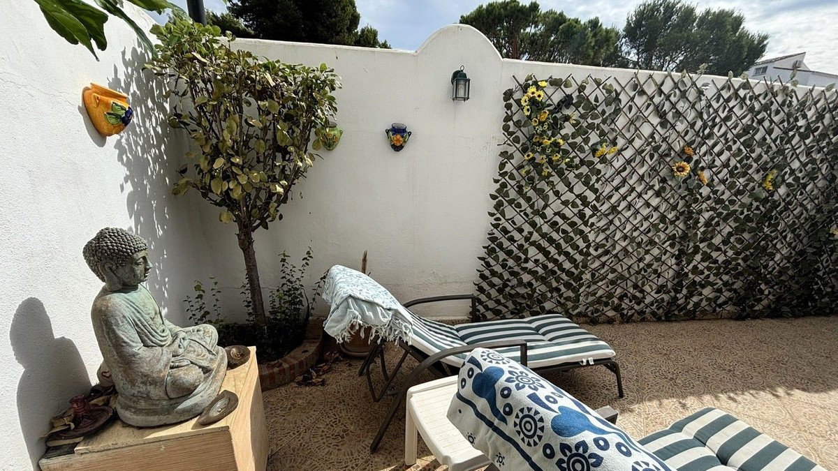 Private patio with Buddha statue, lounge chairs, and decorative trellis wall.