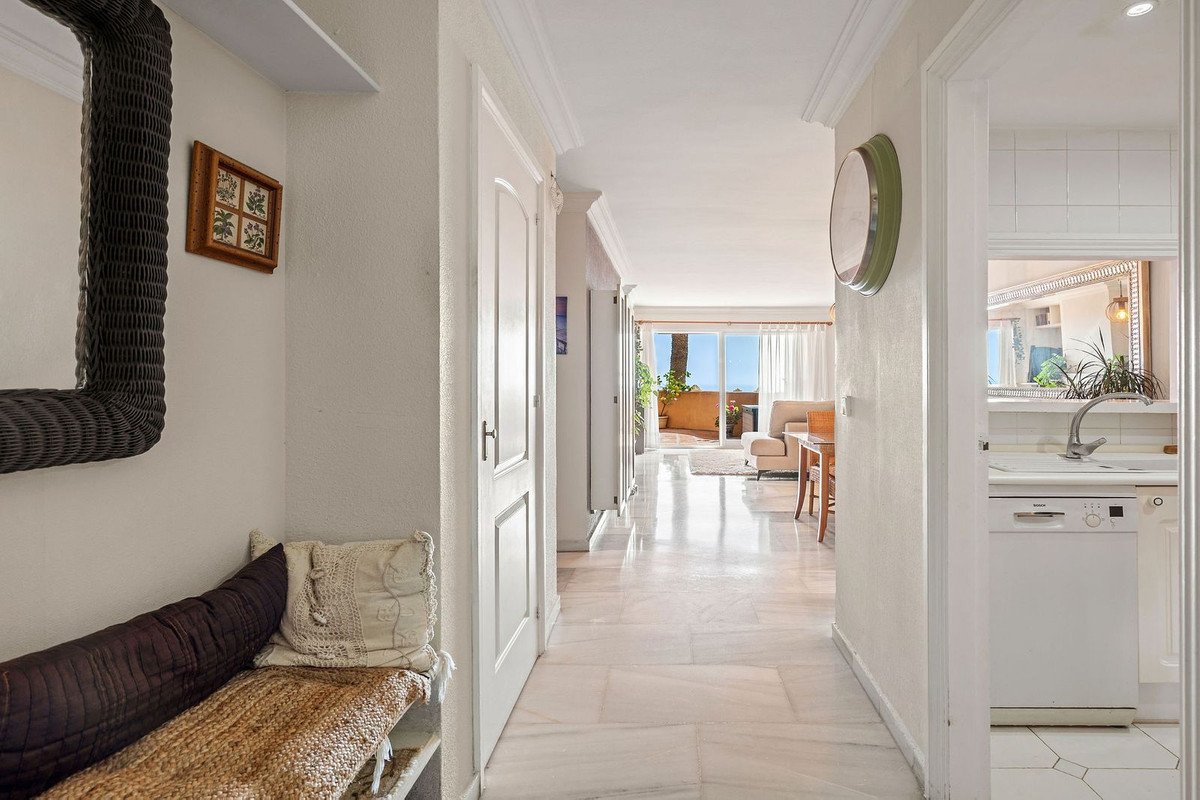 Bright hallway with seating, leading to living area with ocean view