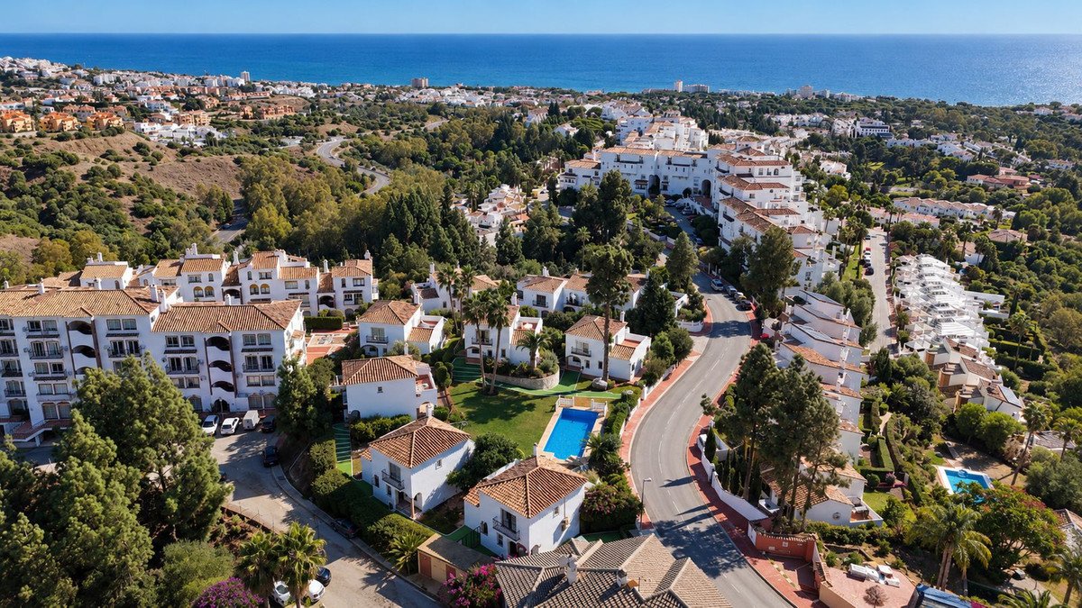 Aerial view of coastal residential complex with swimming pools and ocean view