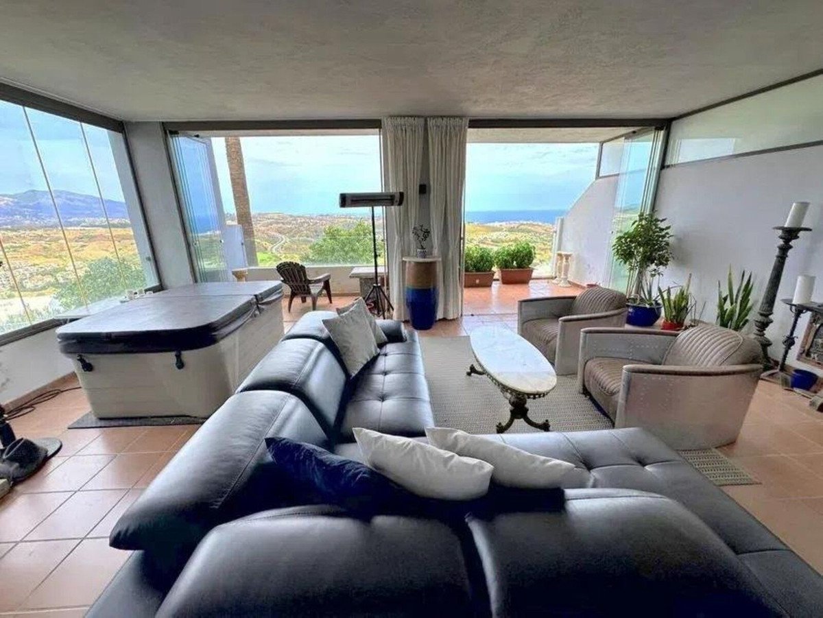 Living room with ocean view, black leather sofa, and jacuzzi
