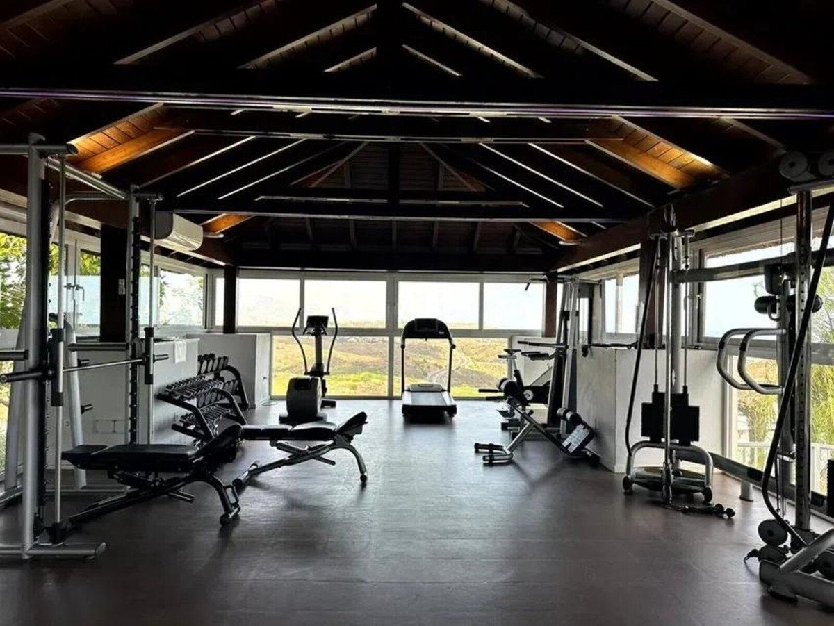 Home gym with various equipment and mountain view through large windows