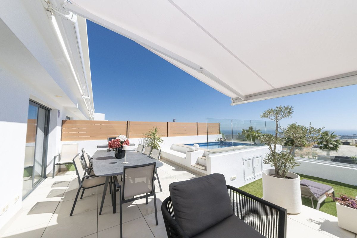 Spacious terrace with dining area, small pool, and panoramic sea view under a clear blue sky.