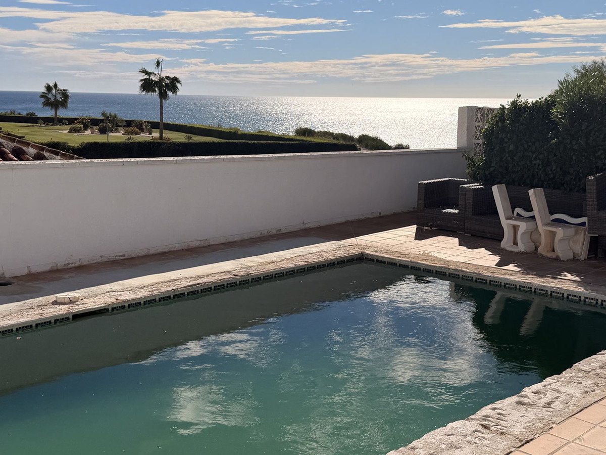 Outdoor pool with sea view and patio furniture