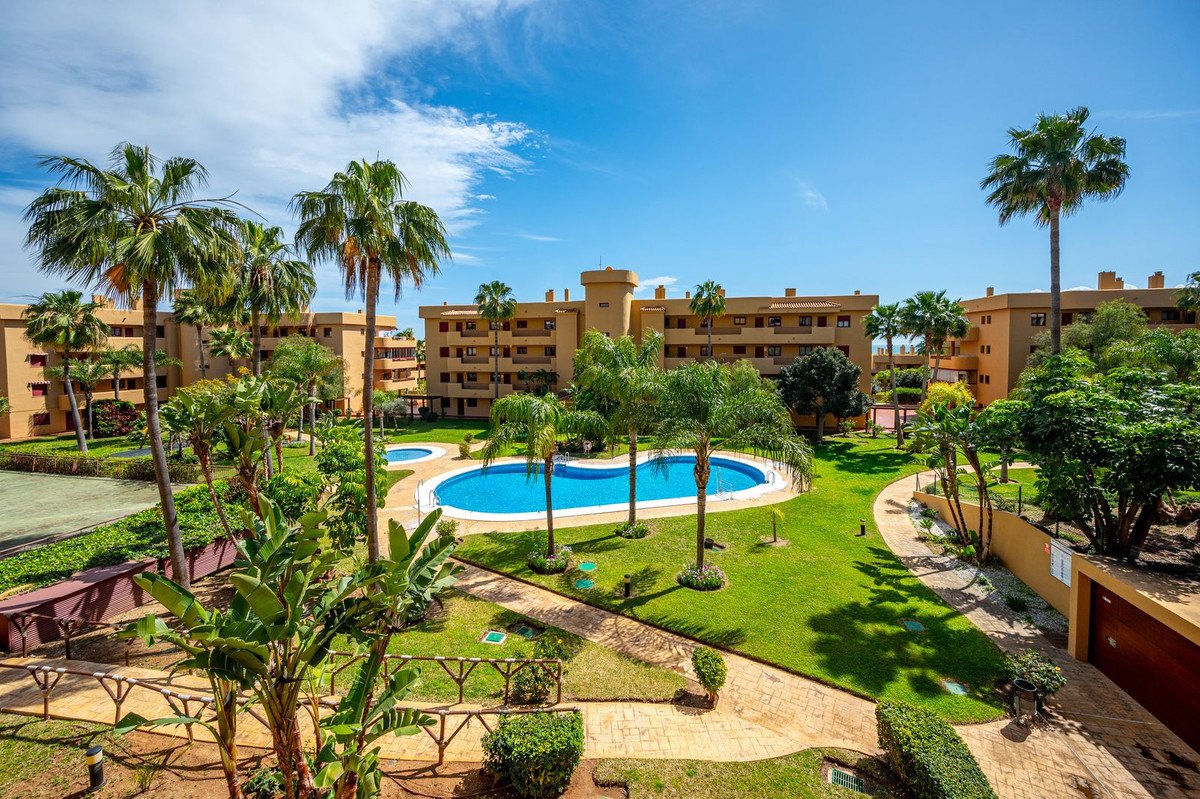 Apartment with a pool view surrounded by palm trees and greenery