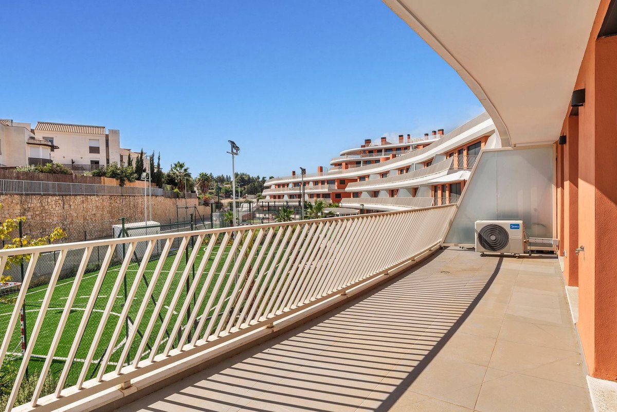 Balcony overlooking a sports field with modern apartment buildings