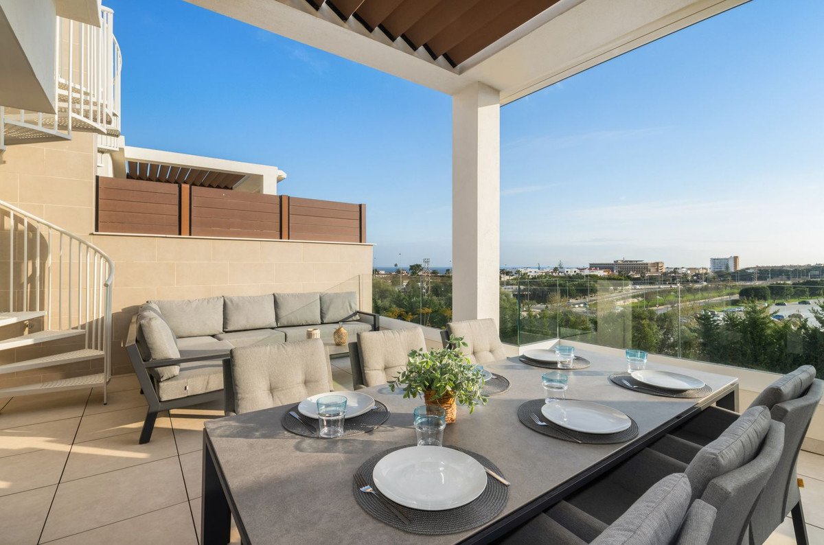 Spacious terrace with dining set, comfortable seating, and a scenic view of the cityscape and trees.