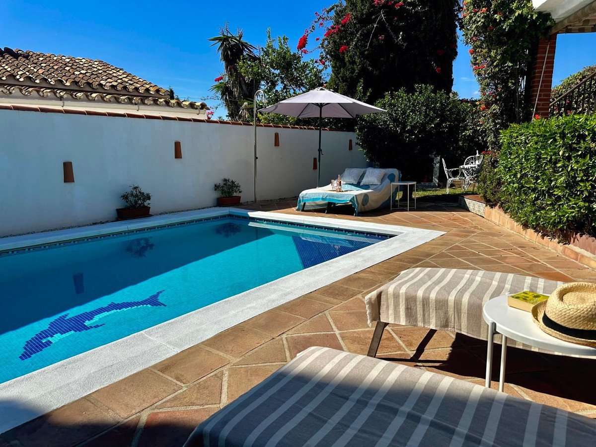 Private outdoor patio with swimming pool, lounge chairs, and umbrella.