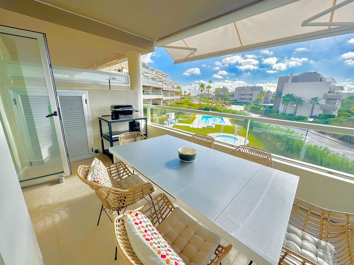 Balcony with dining table, chairs, and view of pool and buildings