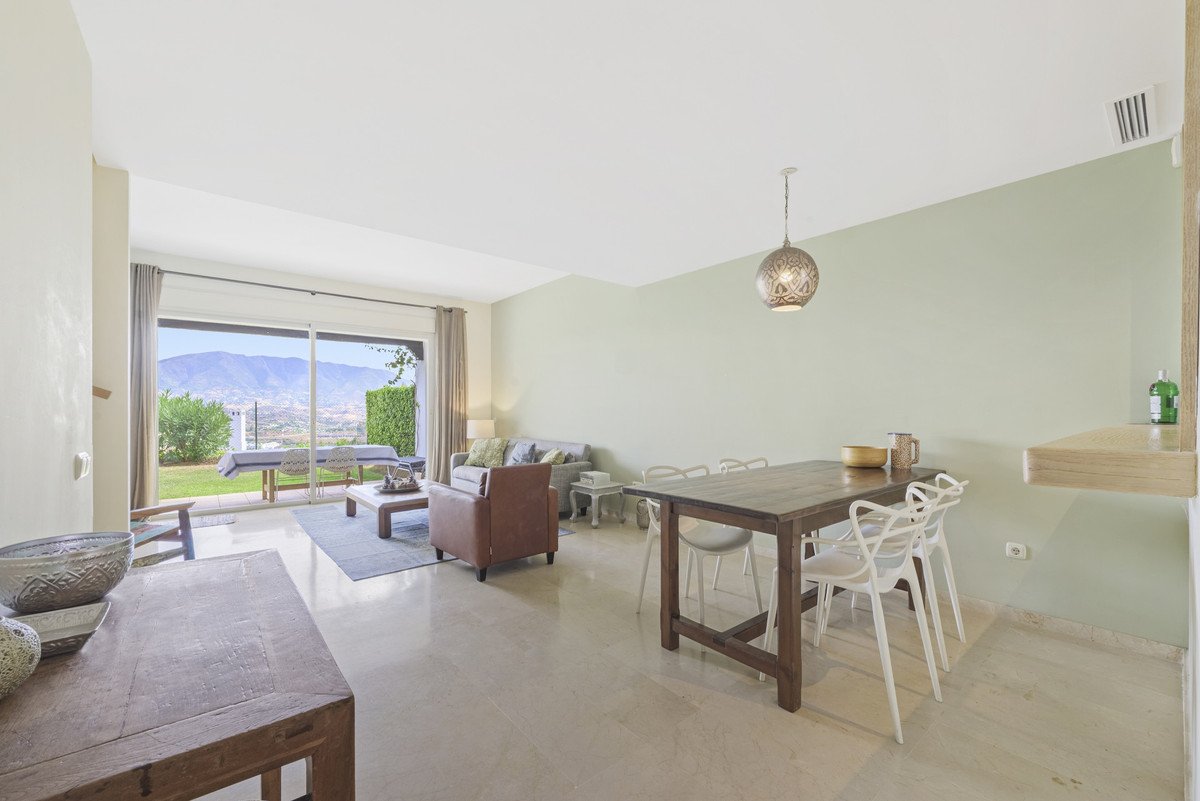 Spacious living and dining area with large glass doors opening to a terrace with a stunning mountain view.