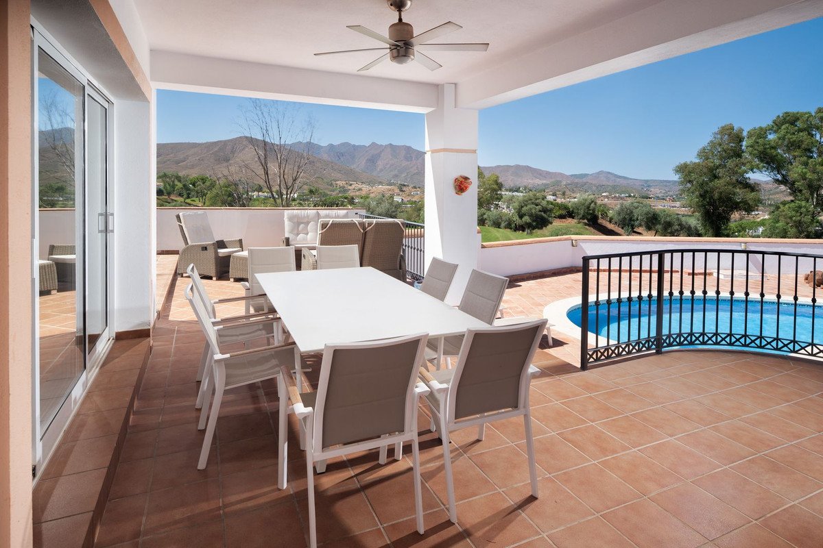 Outdoor patio with dining table, chairs, and pool overlooking mountains