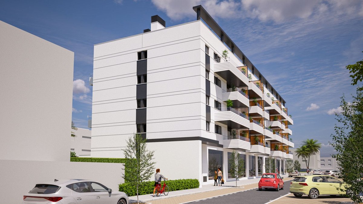 Modern apartment building with multiple balconies and street-level retail spaces on a sunny day.