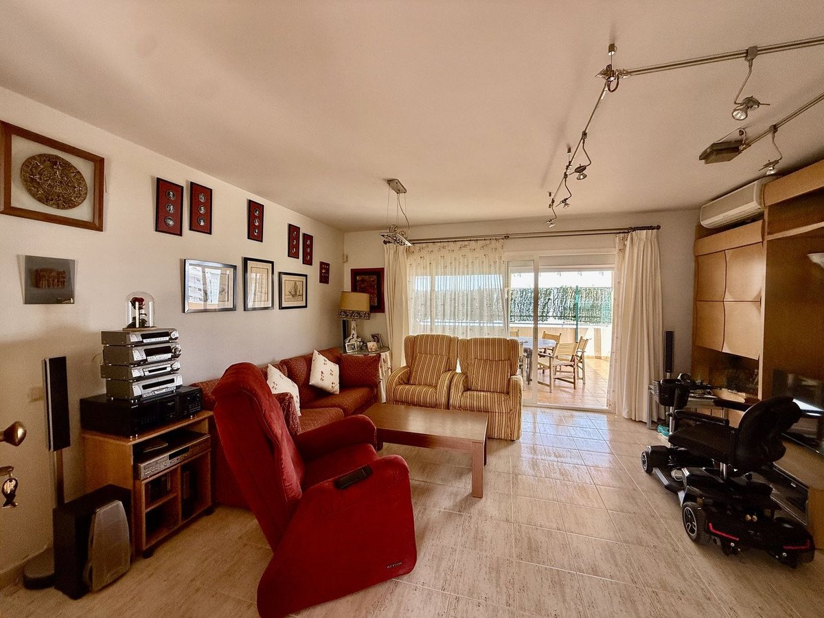 Spacious living room with red sofa, striped chairs, and sliding doors to patio