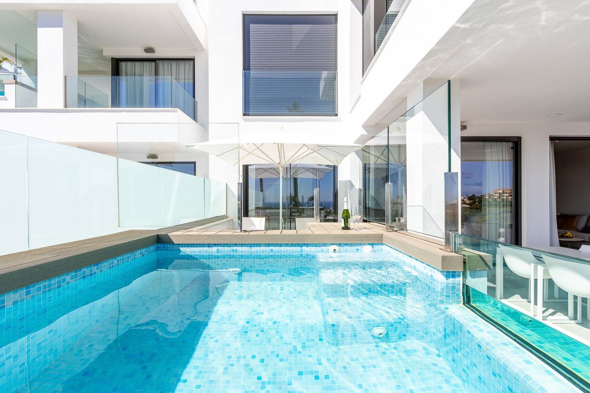 Modern villa with a private pool, terrace, and sea views. Glass railings and white furniture. Perfect for luxury holidays.