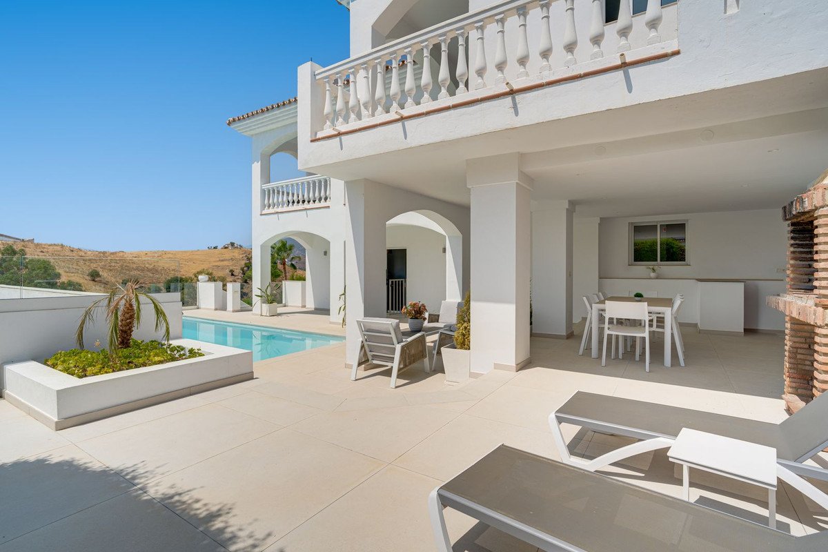 White two-story house with swimming pool and outdoor seating area