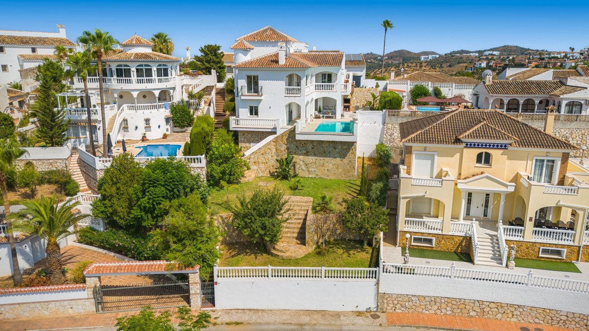 Luxurious white mansion with terracotta roof and swimming pool overlooking scenic hills