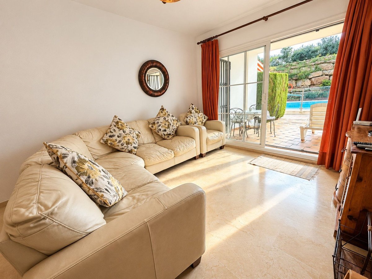 Living room with beige sofas, patio access, and pool view