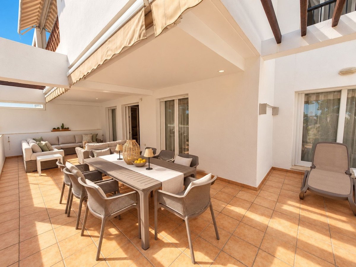 Spacious terrace with outdoor dining table, chairs, lounge sofa, and chaise lounge. Perfect for al fresco living.
