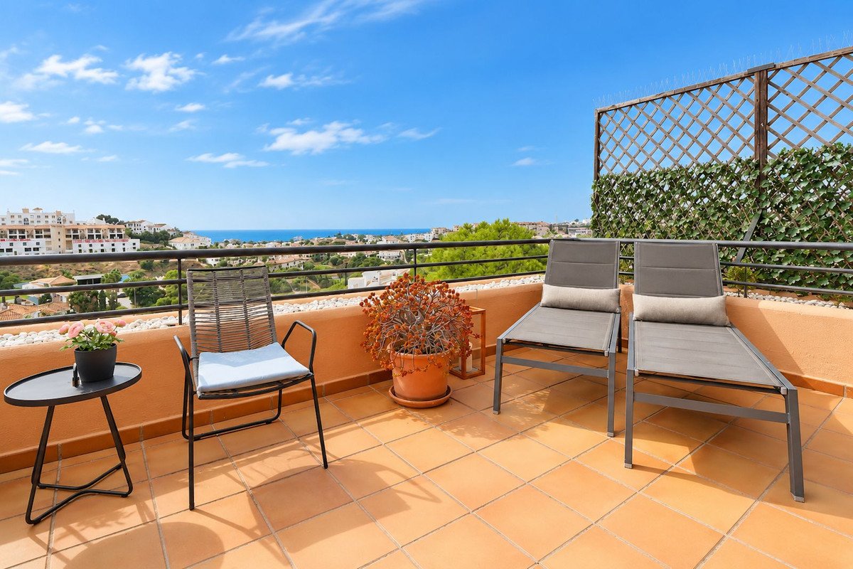 Terrace with sea view, lounge chairs, and a chair with a small table, perfect for relaxation.