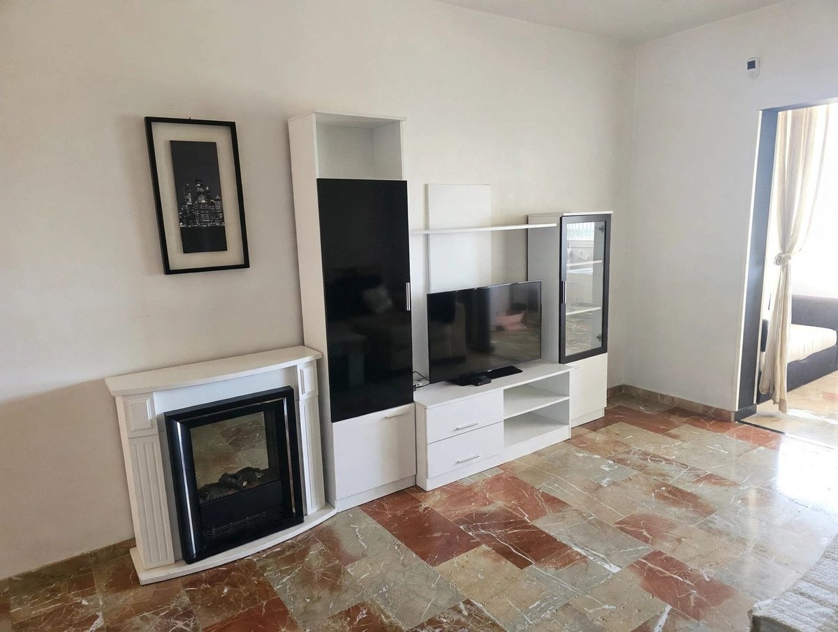 Living room with a fireplace, TV unit, and a framed artwork on the wall.