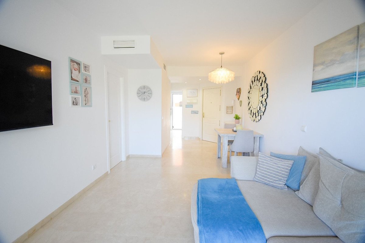 Modern living and dining area with a sofa, dining table, and artwork on the wall.