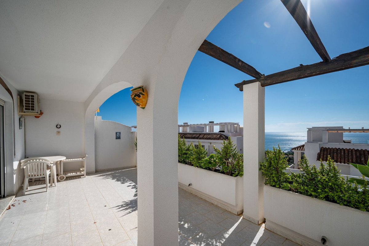 White terrace with sea view, outdoor seating, and arched architecture
